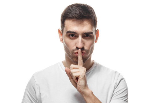 Handsome strict man with shh gesture, asking for silence or to be quiet, isolated on white background