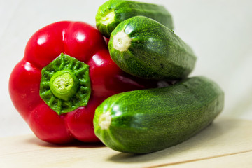 soft focus of fresh red pepper and green zucchini on a white background