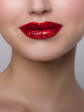 Close-up of woman's lips with bright fashion red glossy makeup. Macro bloody lipgloss make-up