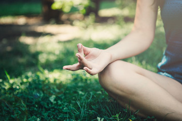 Young yoga woman practitioners yoga on nature.