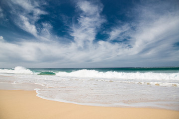 Wellen, Strand und blauer Himmel