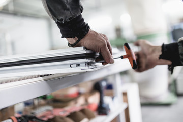 Manual worker assembling PVC doors and windows. Manufacturing jobs. Selective focus. Factory for aluminum and PVC windows and doors production.