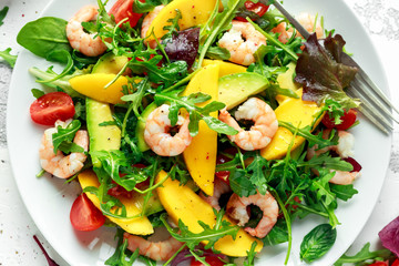 Fresh Avocado, Shrimps, Mango salad with lettuce green mix, cherry tomatoes, herbs and olive oil, lemon dressing. healthy food
