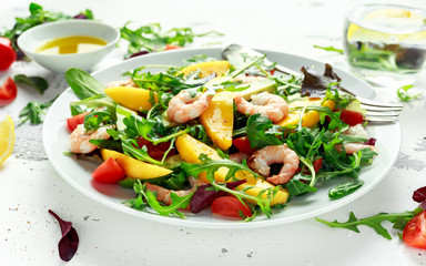 Fresh Avocado, Shrimps, Mango salad with lettuce green mix, cherry tomatoes, herbs and olive oil, lemon dressing. healthy food