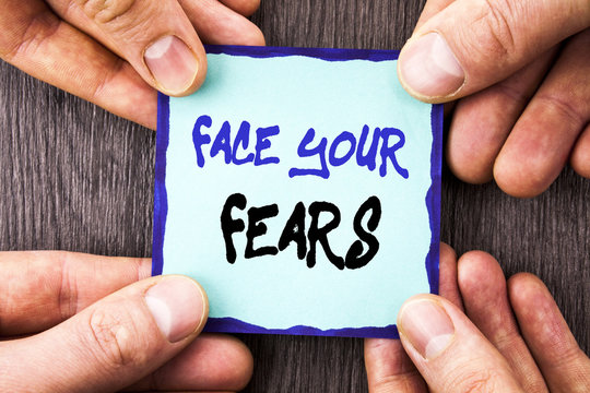 Handwriting Announcement text showing Face Your Fears. Conceptual photo Challenge Fear Fourage Confidence Brave Bravery written on Sticky Note Paper Holding Hand with Finger.