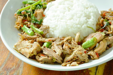 spicy stir fried braised pork leg with basil leaf and rice on plate