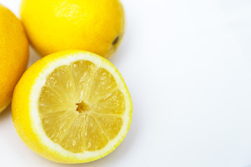 Obraz na płótnie Canvas three yellow lemon one in a cut on a white background