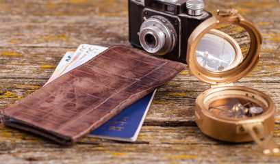 A wallet, money and other items are on the table of old boards.