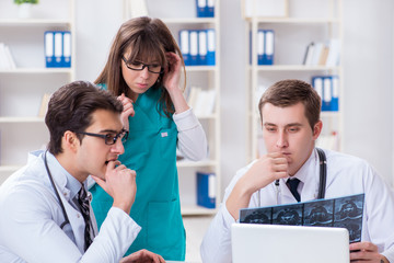 Fototapeta premium Three doctors discussing scan results of x-ray image