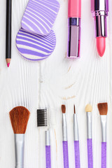 Set of cosmetics and make up tools. Beauty products on white wooden background, space for text. Flat lay of brushes for makeup, top view.