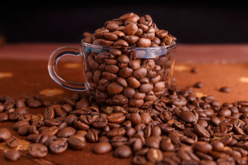 coffe beans in transparent mug on burlap background