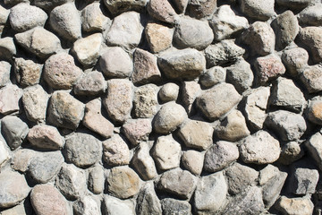 Texture laid out of stone, a wall made of stones on a cement solution