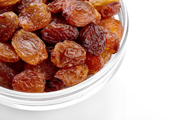 bowl of raisins on a white background. Dried grapes.