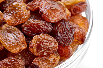 bowl of raisins on a white background. Dried grapes.