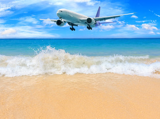 Fototapeta na wymiar Passenger airplane flying above tropical beach in Phuket, Thailand. Amazing view of blue sea and golden sand.