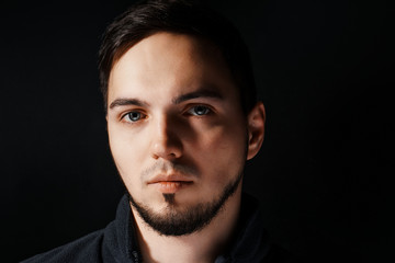 Portrait of young and handsome businessman holding a jacket isolated on black background. Portrait of handsome business man in suit on black background. Studio fashion portrait.