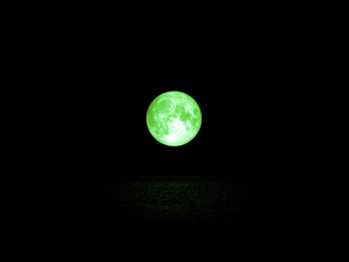 green full moon and light reflection on water surface