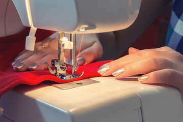 Woman sews red christmas sock