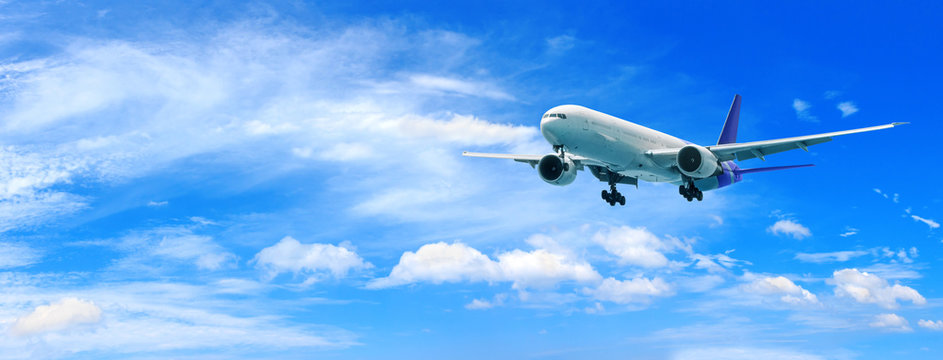 Passenger Airplane Flying Above Clouds. View From The Window Plane To Amazing Sky With Beautiful Clouds.