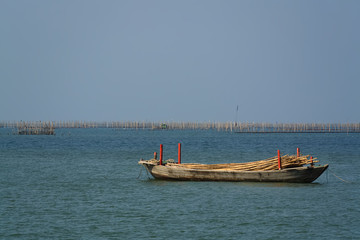 Obraz premium Small Wooden Boat Floating in The Sea
