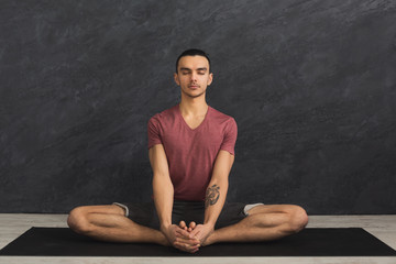 Fototapeta na wymiar Young man practicing yoga, relax meditation pose