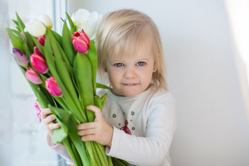 baby on the window with flowers