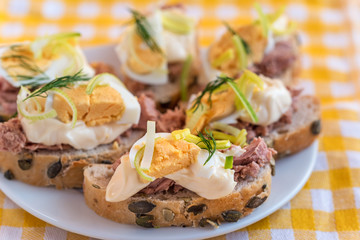 Bruschetta, snack sandwiches with tuna, egg and mayonnaise decorated by dill.