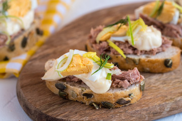 Bruschetta, snack sandwiches with tuna, egg and mayonnaise decorated by dill.