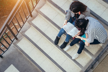 A group of teenage student in university smiling and reading the book in summer holiday.