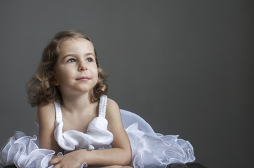 Children's emotions: a dreamy child in a smart white dress