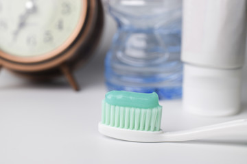 Green toothpaste on a toothbrush on white background