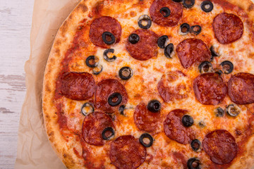 The salami pieces with the cut olives baked with cheese