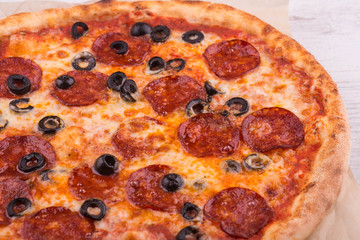 Salami olives pizza under cheese with ketchup
