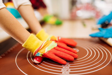 Childrens hands in gloves, caramel making