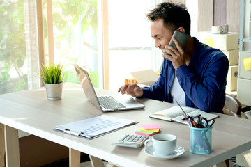 Young business owner of the SME start up company are get purchase orders from customers in the online trading business with a computer laptop in the Home Office