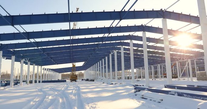 Construction of a modern factory or warehouse, modern industrial exterior, panoramic view, Modern storehouse construction site, the structural steel structure of a new commercial building