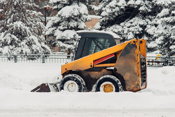 the snowplow stands on the street during the day