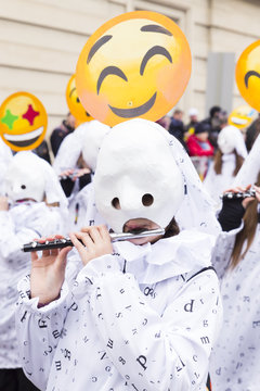 Steinenberg, Basel, Switzerland - February 19th, 2018. Portrait of a single carnival participant in white costume playing piccolo flute