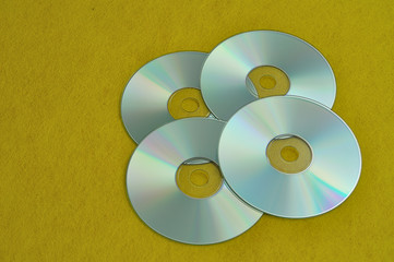 Four cd's on a yellow background