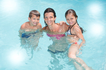 single mother with son and daughter play in pool summer with fun love