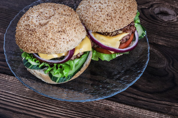 Two burgers on a plate.