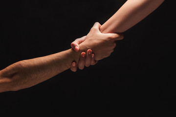 Hands of man and woman in love, isolated on black