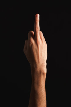 Man showing middle finger at black background