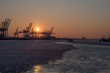 Fototapeta na wymiar Hamburger Hafen mit Eis auf der Elbe und Sonnenuntergang