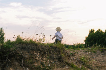 Child on the mountain and evening sunset