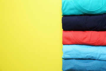 close up of rolled colorful clothes on yellow background