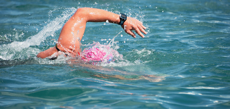 Swimmer swimming crawl in blue sea,training for triathlon