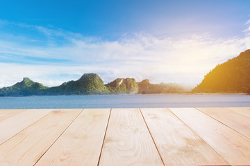 Empty wooden table with sea with mountain and blue sky abstract background.