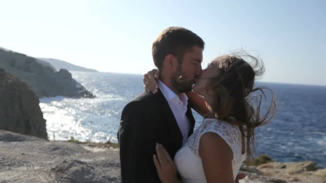 Bride and groom kissing by the sea on their wedding day. Wedding photosession. Greece