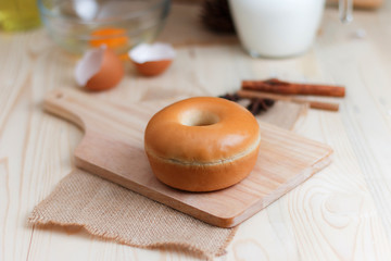 Fototapeta na wymiar Home made donut on wood cut board with bakery ingredients on wooden table select focus shallow depth of field